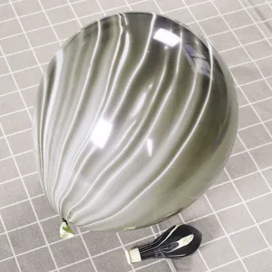 Macro detail of thick black and white agate marble patterned latex balloon on checkered background