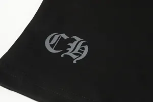 Detailed macro view of silver Gothic CH logo print on black cotton jersey fabric t-shirt