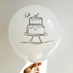 Close-up of a white latex balloon with a black line art cake print design.