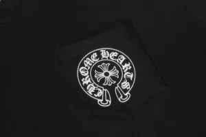 Close-up detail of white horseshoe and cross logo print on black cotton pocket T-shirt