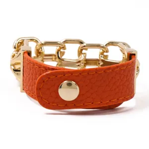 Detailansicht des orangefarbenen Lederarmbands im Punk-Stil mit klobiger Goldkette