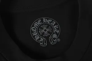 Close-up of Chrome Hearts horseshoe logo printed on a black cotton T-shirt neckline