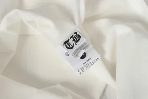 Detailed macro view of the internal white clothing wash care label on a casual t-shirt