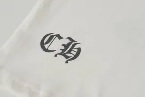 Close-up detail of Gothic CH logo print on white cotton T-shirt fabric