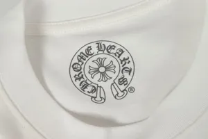Close-up detail of the gothic brand logo printed on the inner neck of a white t-shirt