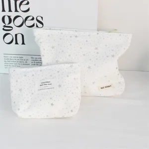 White canvas cosmetic bag set with silver star glitter, portable storage pouch for travel.