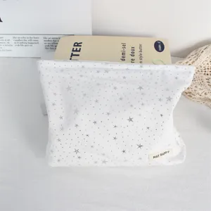 White cosmetic bag featuring silver stars pattern and compact detail design for storage.