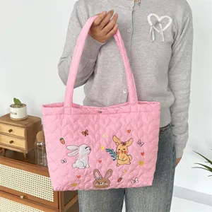 Cute pink quilted tote bag with adorable cartoon rabbit embroidery for daily commute and casual use.