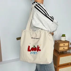 Práctico bolso tote de lona con bordado de cerezas y cordón para uso diario casual.