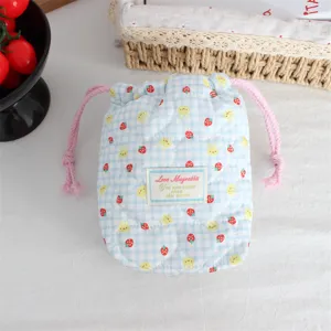 Detailed view of cute blue plaid quilted drawstring pouch with strawberry and rabbit prints.