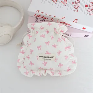 Primer plano detallado de la bonita bolsa acolchada con cordón y lazos rosados y volantes.