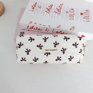 Grazioso astuccio cilindrico trapuntato con fiocchi neri design per studenti e scuola.
