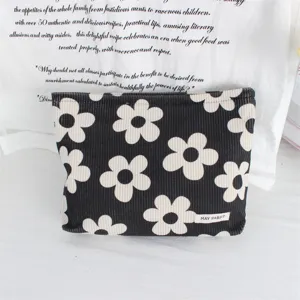 Corduroy cosmetic bag with black and white flower pattern, portable zipper storage pouch for travel.