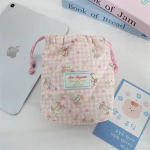 Detalle de la bolsa de almacenamiento acolchada a cuadros rosas, bolsa con cordón y tierno perrito.