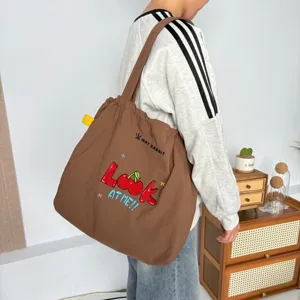 Bolso tote de lona de gran capacidad con bordado de cerezas, ideal para el desplazamiento diario.