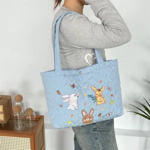 Cute quilted tote bag with adorable rabbit embroidery, stylish light blue casual shoulder bag.