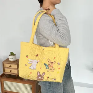 Cute quilted yellow tote bag with adorable cartoon rabbit embroidery for daily commute and travel.