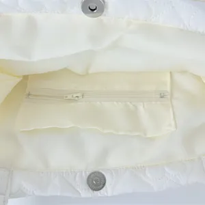 White quilted heart tote bag interior detail, showing inner zipper pocket and magnetic snap.