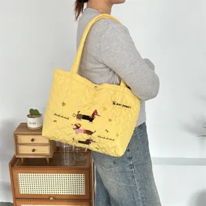 Yellow quilted heart tote bag with cute dachshund embroidery and comfortable shoulder straps.
