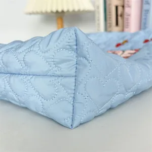 Light blue quilted tote bag with cute heart embroidery, soft fluffy shoulder bag design.