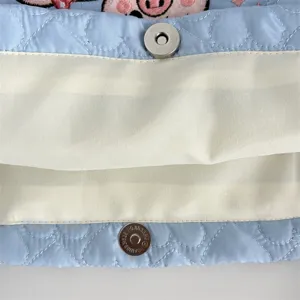 Close-up detail of light blue quilted tote bag interior with magnetic snap closure.