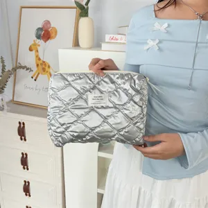 Detailed view of the Korean style silver PU quilted cosmetic pouch with a small woven label.
