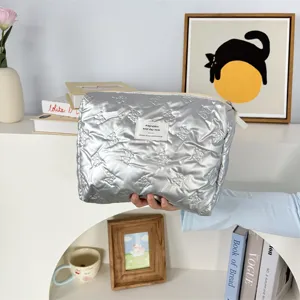 Silver quilted makeup bag, aesthetic toiletry pouch with zipper, portable storage bag.