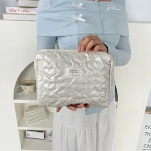 Silver quilted heart cosmetic pouch detail, portable zipper makeup bag for daily travel.