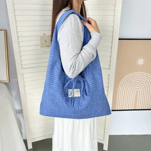 Retro blauwe geruite canvas shopper met handig trekkoord en stijlvol schouderdesign.