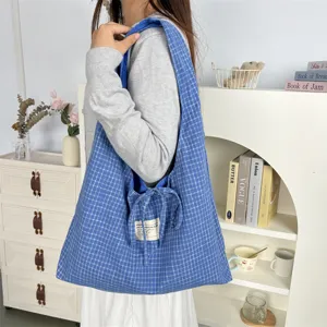 Gedetailleerd overzicht van blauwe ruit casual schoudertas, grote capaciteit tote tas met strik.