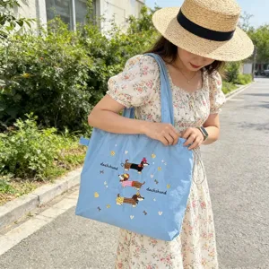 Primo piano esterno che mostra il ricamo del bassotto e il design con coulisse della borsa.