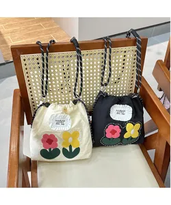 Detailed view of cute floral embroidered canvas phone bag featuring stylish strap.