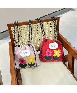 Detailed view of cute floral embroidered fabric phone crossbody bag with drawstring design.