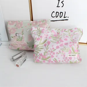 Dettaglio della pochette cosmetica floreale retrò con tessuto jacquard e design portatile.