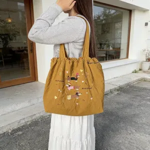 Borsa shopper in tela giallo senape con simpatici bassotti ricamati e comoda coulisse.