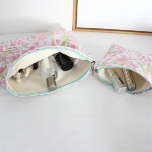Vista dettagliata della borsa cosmetica in tela floreale con ampio spazio interno e grazioso motivo rosa.