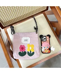 Close-up detail of the pink embroidered flower crossbody phone bag placed neatly on a chair.