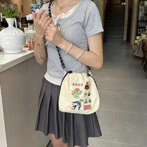 Close-up of cute canvas crossbody phone bag featuring colorful floral and bear embroidery.