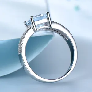 Nahaufnahme des eleganten Silberrings mit hellblauem quadratischen Edelstein und Zirkoniasteinen.