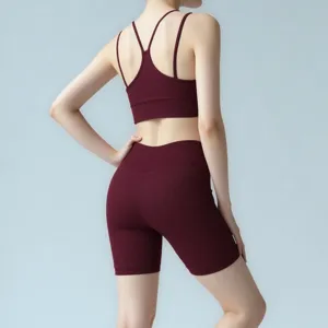 Back view of a maroon ribbed yoga set featuring a cross-strap sports bra and high-waist shorts.