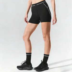Detailed view of women's black athletic shorts featuring high waist and contrast stripe design.