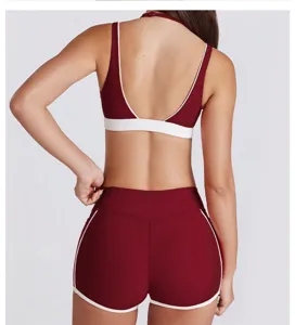 Gedetailleerd achteraanzicht van de bordeauxrode contrast halter sport-bh en fitnesshorts set.