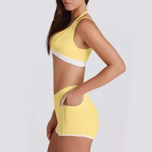 Gele color-block halter sport-bh en handige zak fitness yoga shorts activewear set.