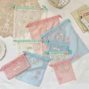 Gedetailleerde close-up van pastelkleurige organza opbergzakjes met schattige borduursels.