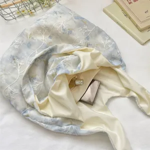 Detailed view of the gentle floral embroidered canvas shoulder bag, showing delicate texture.