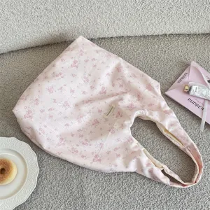 Nahaufnahme der Stofftextur der rosa Blumen-Stofftasche, ästhetische Lifestyle-Requisitenaufnahme.