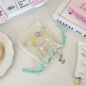 Minzgrünes Netztruhen-Aufbewahrungsbeutel mit Kordelzug, Schleifenstickerei und tragbarem Design.