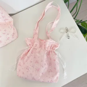 Nahaufnahme der rosa Umhängetasche mit Blumenmuster, süßen Spitzenkordeln und Rüschen.
