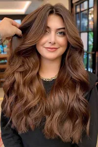 Vista dettagliata di extension per capelli mossi castani lunghi, con consistenza e volume naturali.