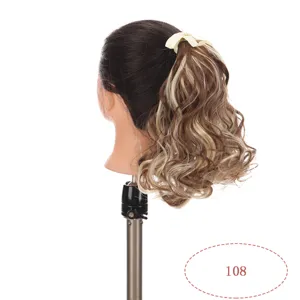 Detail view of brown blonde highlighted curly synthetic hair ponytail extension with bow.